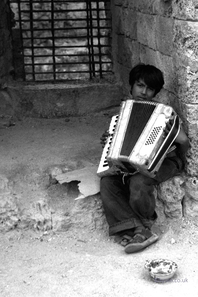 Taken in Rhodes old town shortly after arriving on a coach. We saw this lad with an accordion, I gave him a few euros and asked if I could take his picture.   I cannot recall what he played but music is everywhere in Greece.